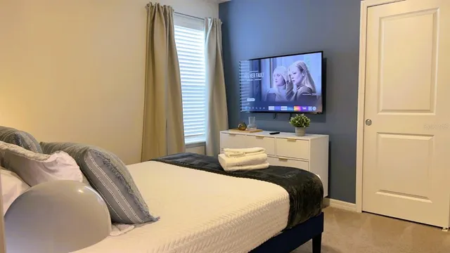 a bedroom with two beds and a flat screen tv