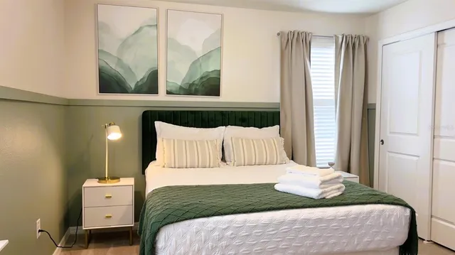 a bedroom with a bed and a flat screen tv