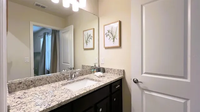a bathroom with a granite countertop shower and a sink