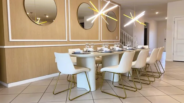 a kitchen with stainless steel appliances granite countertop a sink a stove a refrigerator a center island and chairs