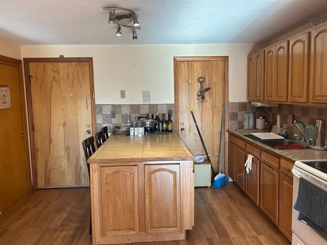 a view of a kitchen with fridge and wooden floor