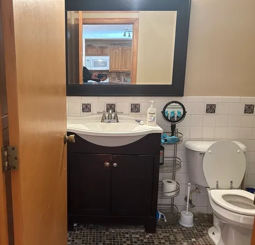 a bathroom with a granite countertop toilet and a shower