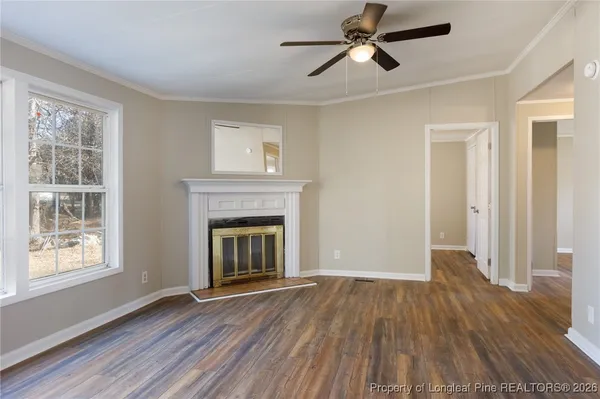 a view of empty room with wooden floor and fireplace