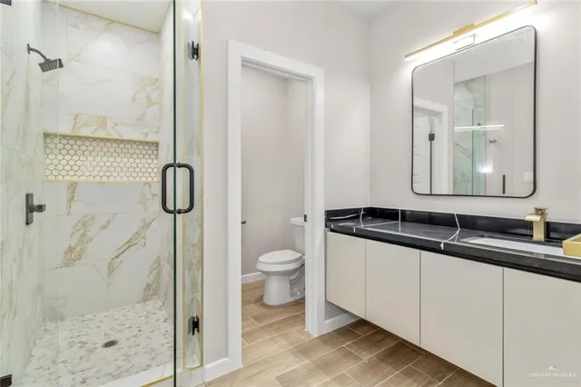 a bathroom with a double vanity sink toilet and shower