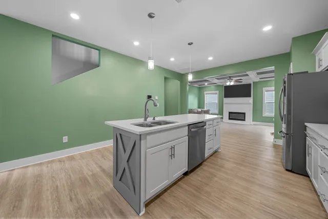 a kitchen with a sink and wooden floor