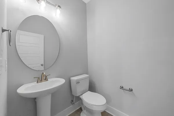 a bathroom with a toilet a sink and mirror