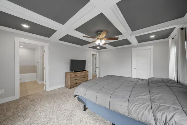 a bedroom with a large bed and a flat tv screen