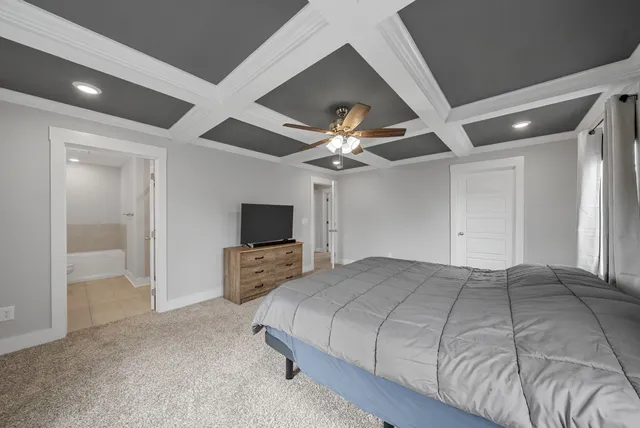 a bedroom with a large bed and a flat tv screen