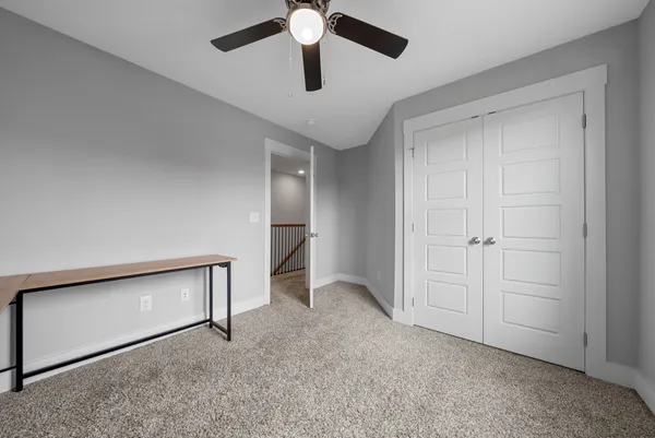 a view of an empty room and chandelier fan