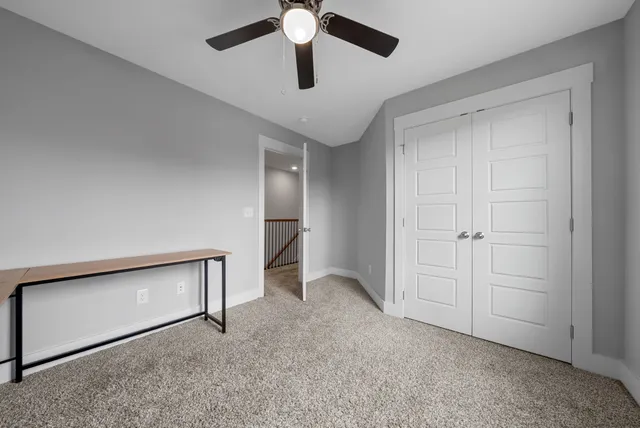 a view of an empty room and chandelier fan