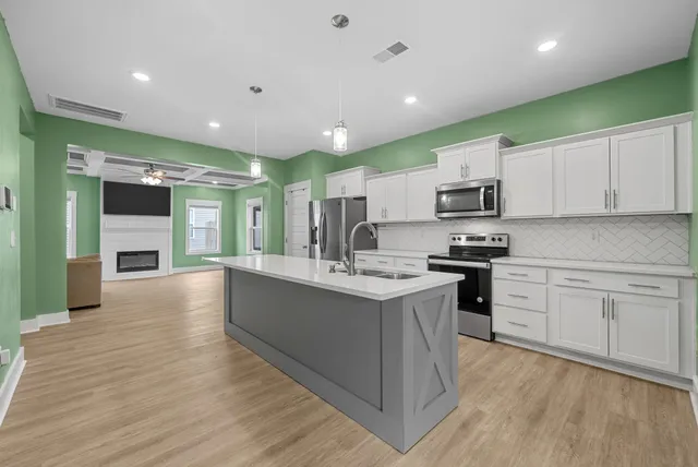 a large kitchen with stainless steel appliances granite countertop a stove and a sink