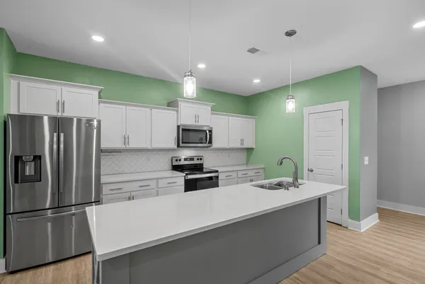 a kitchen with stainless steel appliances a refrigerator sink and microwave
