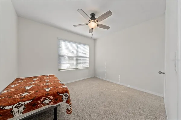 an empty room with fan and windows