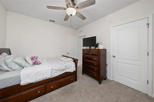 a bedroom with a bed and a flat tv screen on dresser