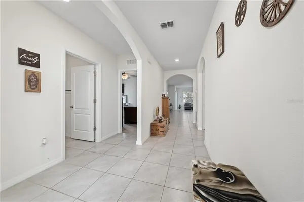 a view of a hallway with wooden floor and a bathroom