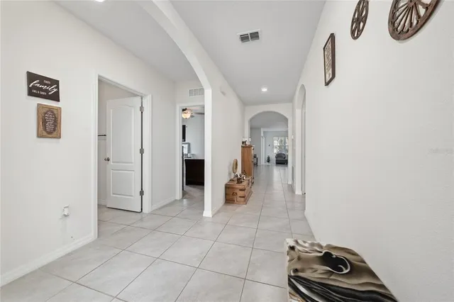 a view of a hallway with wooden floor and a bathroom
