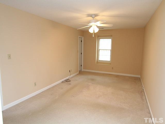 6225 Lookout Loop Raleigh, NC 27612 - Photo 14 of 25 an empty room with a chandelier fan and windows