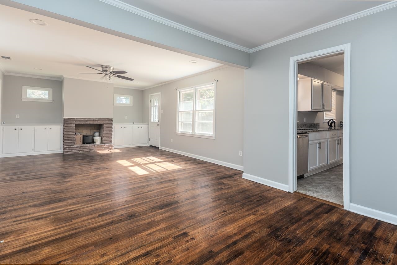 4606 Helene Road Memphis, TN 38117 - Photo 5 of 10 an empty room with wooden floor fireplace and windows