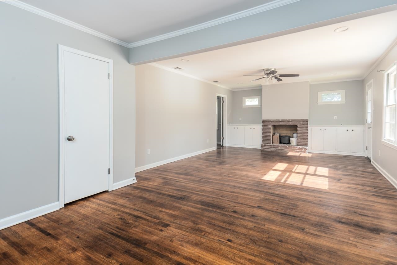 4606 Helene Road Memphis, TN 38117 - Photo 6 of 10 a view of empty room with wooden floor and fireplace