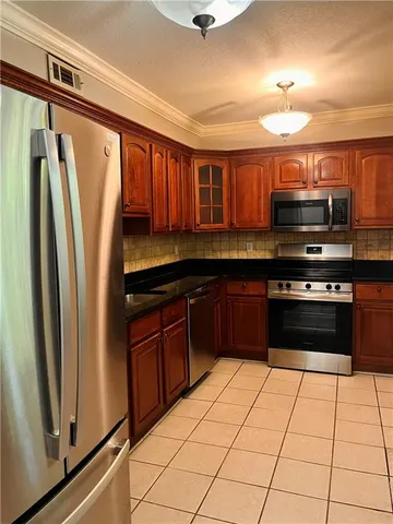 a kitchen with stainless steel appliances granite countertop a refrigerator and a sink