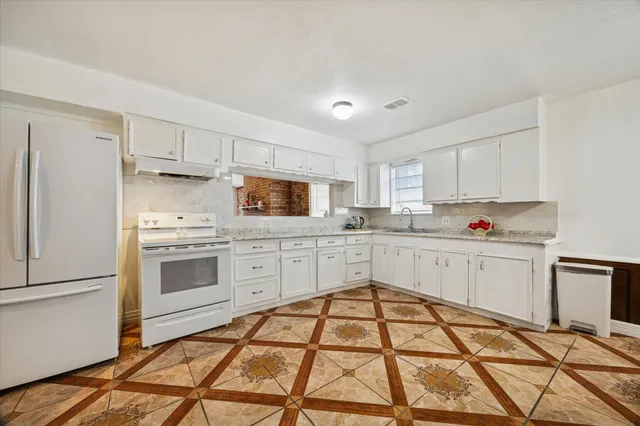 a kitchen with white cabinets and appliances