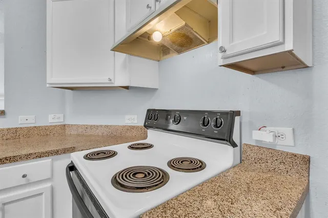 a kitchen with a stove and a white cabinet