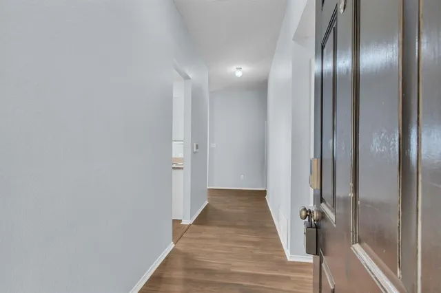 a view of a hallway with wooden floor
