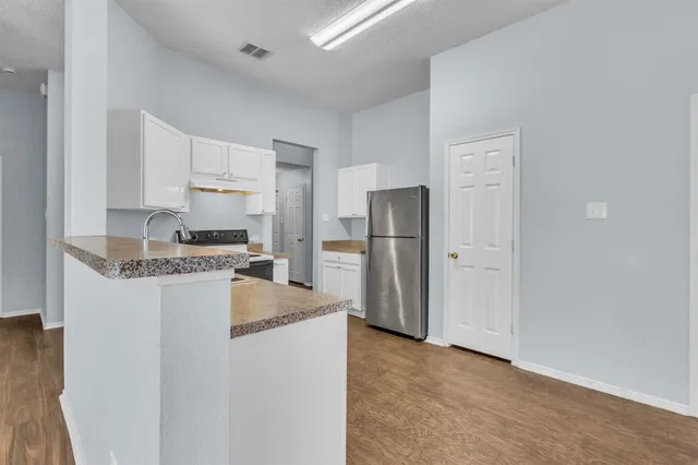 a kitchen with refrigerator a stove and a cabinets
