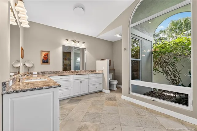 a spacious bathroom with a granite countertop double vanity sink mirror and