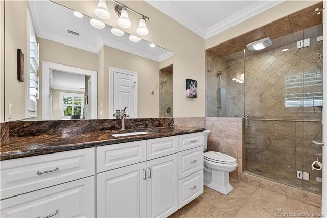 a bathroom with a granite countertop sink a toilet and a mirror