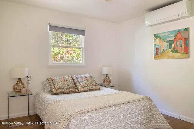 a bedroom with a bed and a painting on the wall