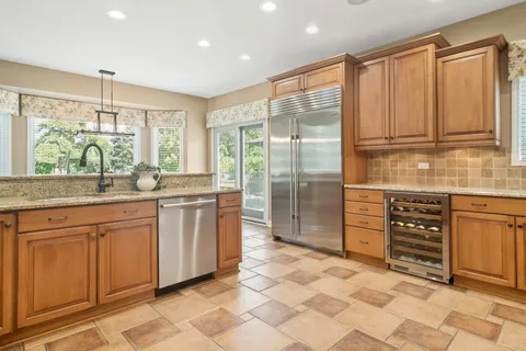 a kitchen with stainless steel appliances granite countertop a stove a sink and a refrigerator
