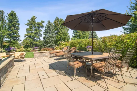 a view of a patio with table and chairs under an umbrella