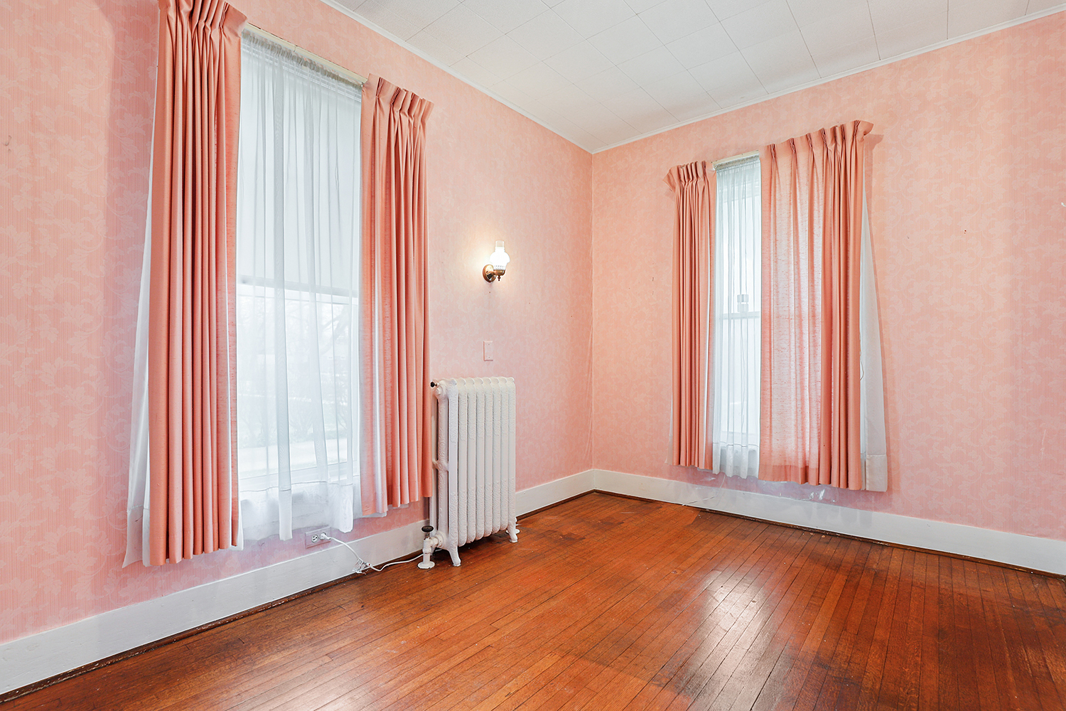 309 East 3rd Street Sandwich, IL 60548 - Photo 18 of 33 an empty room with wooden floor and windows with curtains