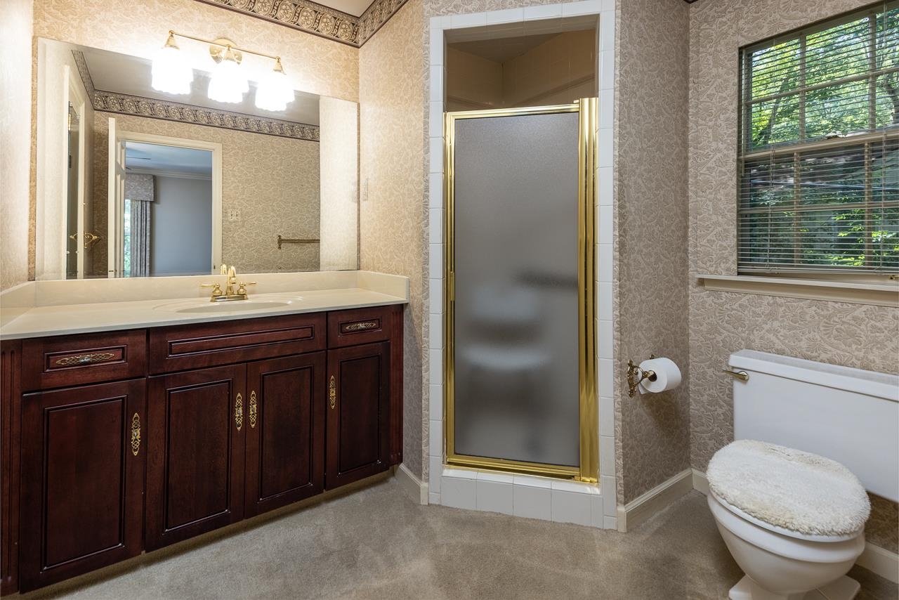 1269 Hayne Road Memphis, TN 38119 - Photo 10 of 24 a bathroom with a granite countertop toilet a sink and a mirror