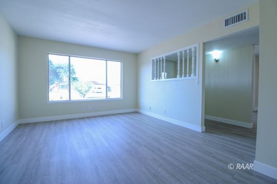 723 West Wilson Avenue Ridgecrest, CA 93555 - Photo 5 of 29 an empty room with wooden floor and windows