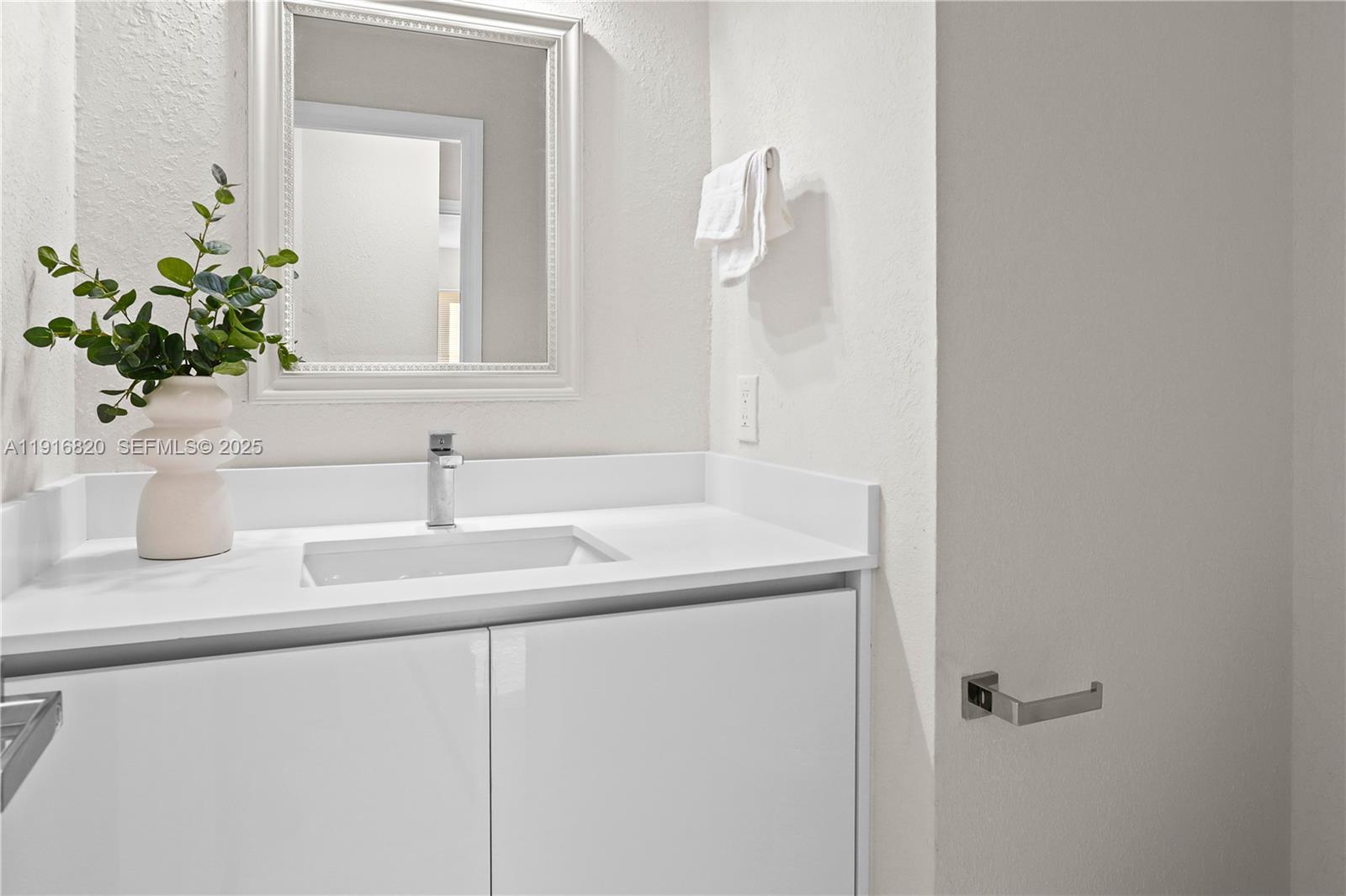 1223 Northwest 125th Terrace Sunrise, FL 33323 - Photo 38 of 89 a bathroom with a sink and a mirror