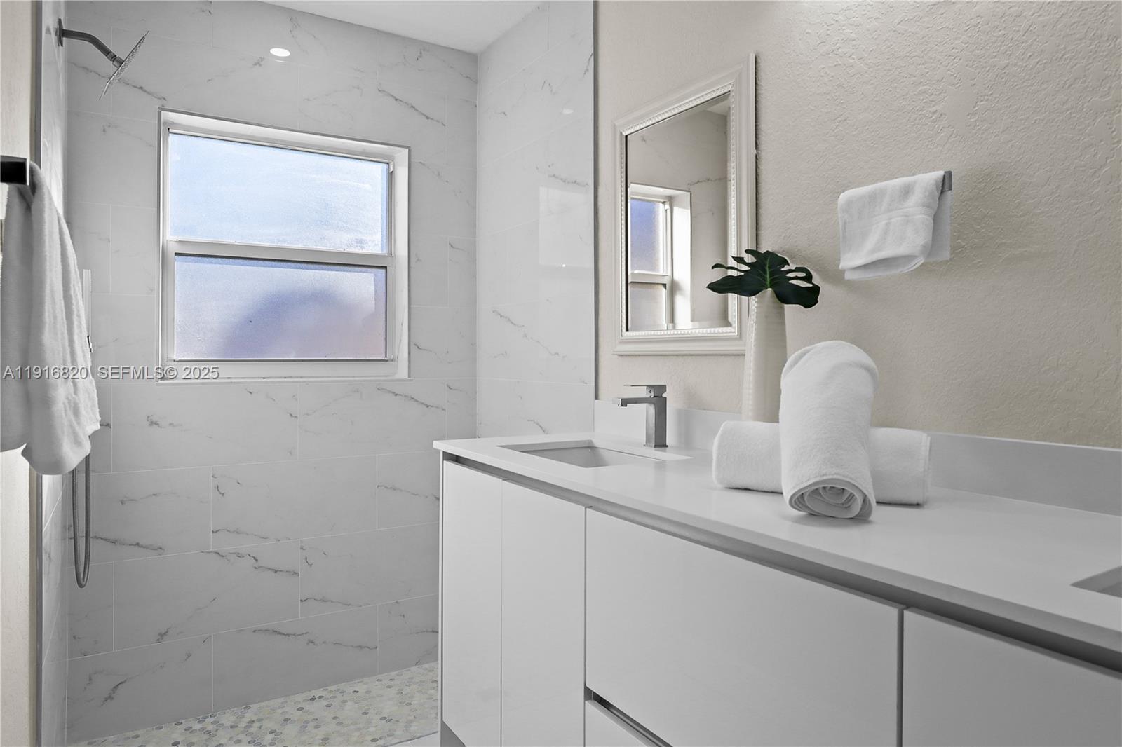 1223 Northwest 125th Terrace Sunrise, FL 33323 - Photo 47 of 89 a bathroom with a sink a vanity and mirror