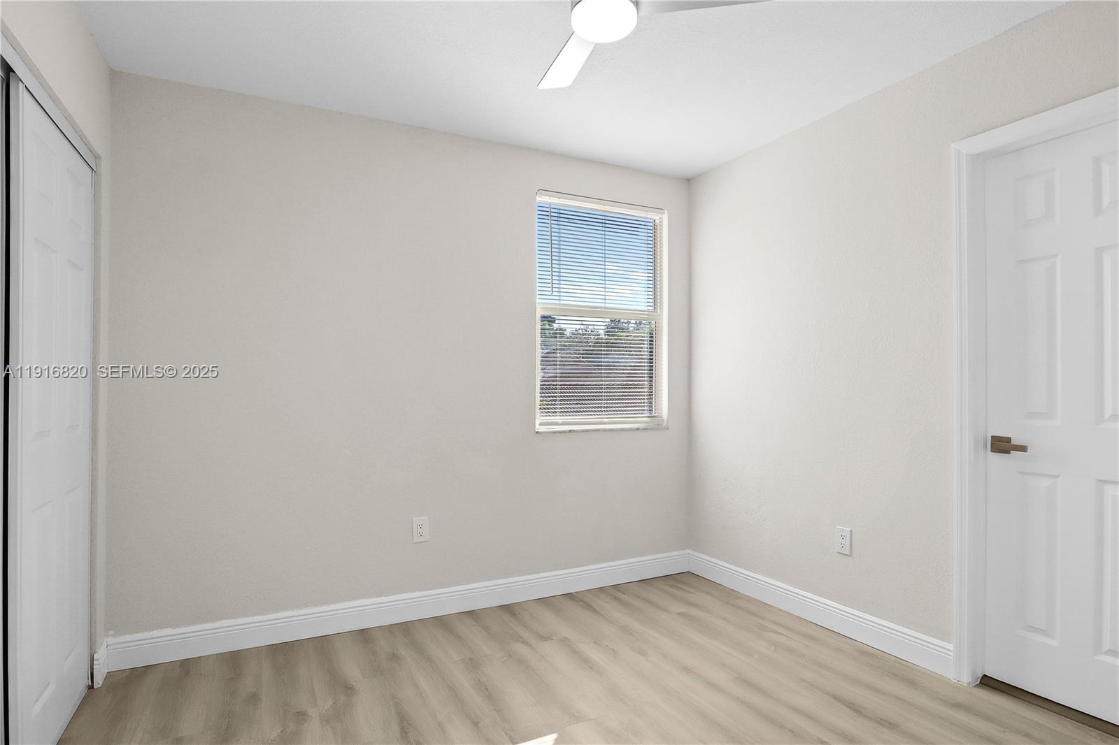 1223 Northwest 125th Terrace Sunrise, FL 33323 - Photo 56 of 89 an empty room with wooden floor and windows