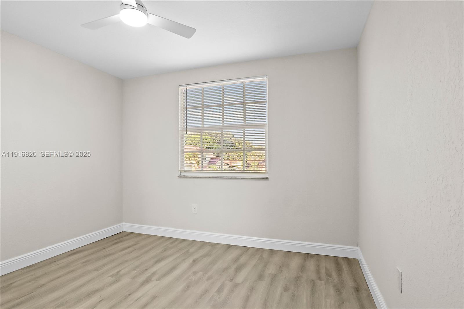 1223 Northwest 125th Terrace Sunrise, FL 33323 - Photo 61 of 89 an empty room with wooden floor and windows