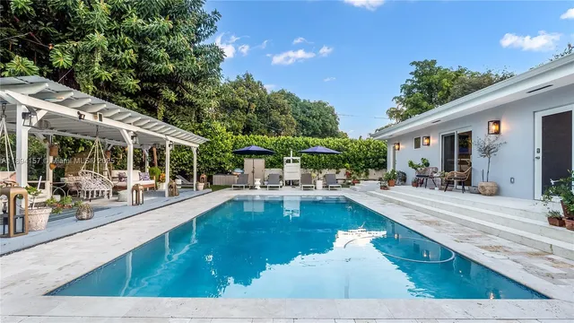 a swimming pool view with a seating space and a garden view