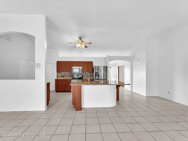 a kitchen with kitchen island granite countertop a stove and a sink