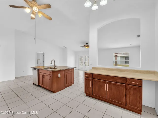 a open kitchen with stainless steel appliances granite countertop a stove top oven a dining table and chairs with the living room view