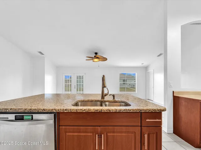 a kitchen with stainless steel appliances granite countertop a sink a stove and refrigerator