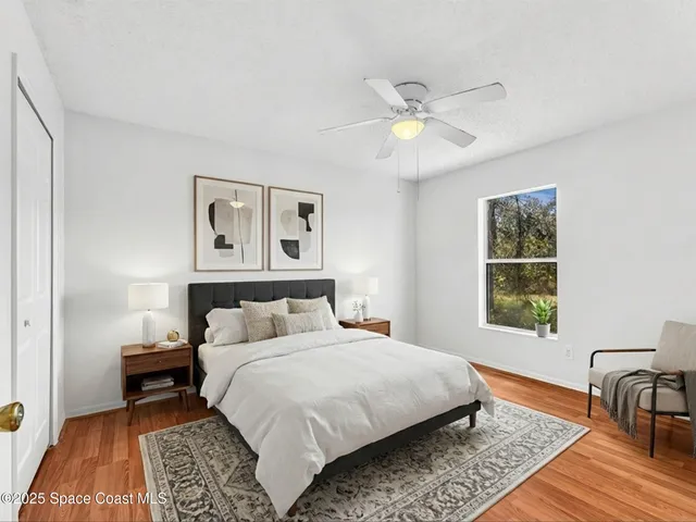 a view of a room with wooden floor and a ceiling fan