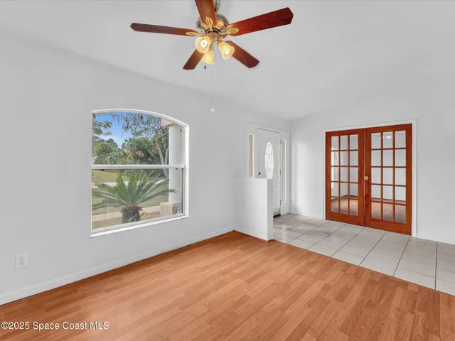 an empty room with wooden floor and windows