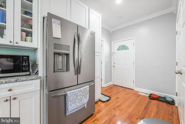 a kitchen with stainless steel appliances granite countertop a refrigerator and a stove top oven