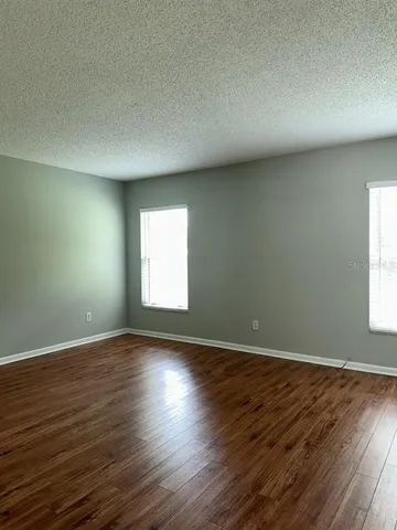 a view of an empty room with wooden floor