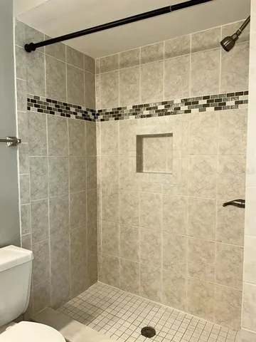 a bathroom with a granite countertop sink mirror vanity and toilet