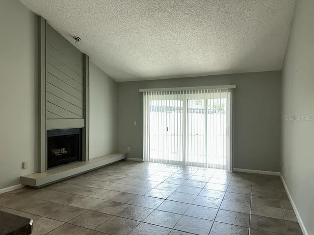 a view of an empty room with a fireplace and a window